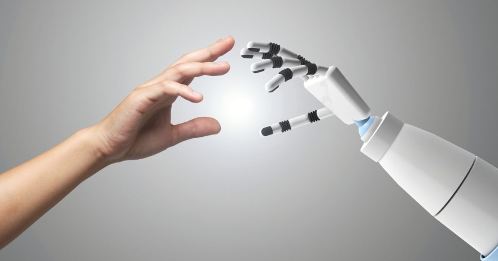 A human hand reaching towards a robot hand.
